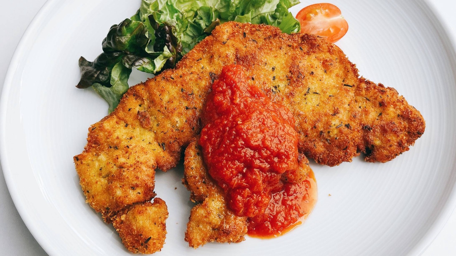 トマトソースを添えた豚肉のミラノ風カツレツ